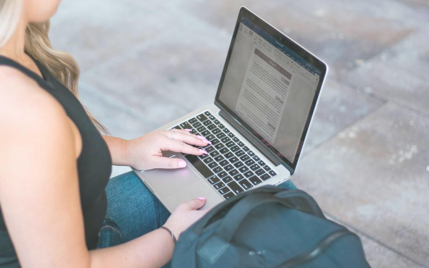 Person arbeitet fokussiert mit Finanzunterlagen und Laptop